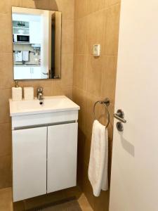 a bathroom with a white sink and a mirror at Alcântara Studio 15 in Lisbon
