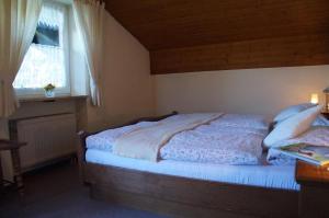 Schlafzimmer mit einem Bett und einem Fenster in der Unterkunft Gästehaus Brunner in Zwiesel