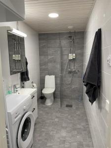 Un baño con ducha, inodoro y lavabo. en High-ceilinged apartment with balcony, en Tampere 14 fotos más