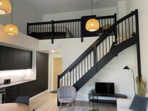 una sala de estar con una escalera en una casa en High-ceilinged apartment with balcony, en Tampere