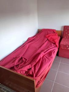 Una cama con una sábana roja encima. en На пъпа на Варна!, en Varna
