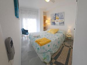 a bedroom with a bed with a yellow blanket on it at MARINA BEACH FRONT in La Herradura
