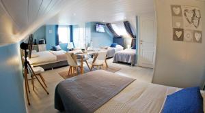 una camera da letto con due letti, un tavolo e delle sedie di B&B Au Coq en Pate a Jalhay
