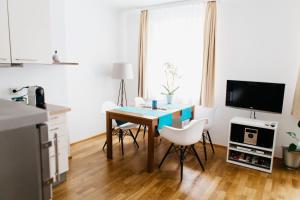 a kitchen with a table with chairs and a television at Home Sweet Apartments - A cozy welcome in Vienna +30 photos