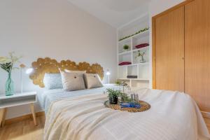 a bedroom with a large bed with a wooden headboard at Pepe’s Apartment Salou in Salou