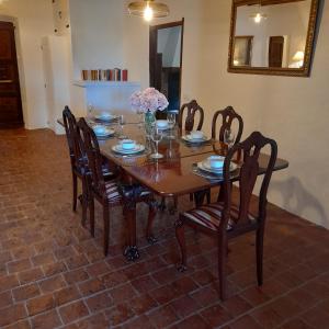 una mesa de madera con sillas y un jarrón de flores. en Mas Puig De Baix, en Olot