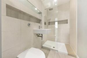 Baño blanco con aseo y lavamanos en BOND STREET STATION 2 BED FLAT, en Londres
