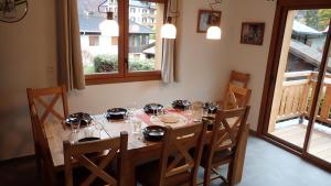 uma mesa de jantar com cadeiras e copos em Chalet Rivendell, Morzine sleeps 10 with garage em Morzine