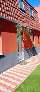 a red house with potted plants on the door at LIVABLŌM "Maison et Parking Privée" in Guesnain