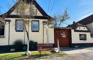 un banc en bois assis devant une maison dans l'établissement Pensiunea Rozalia, à Criţ