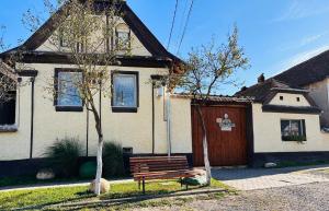 a wooden bench sitting in front of a house at Pensiunea Rozalia in Criţ