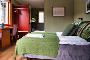 a bedroom with a green blanket on a bed at Sølvgarden Motell in Rysstad