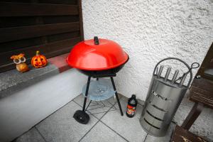 a red grill sitting on a porch with a pumpkin at Alpina Haus in Oberammergau