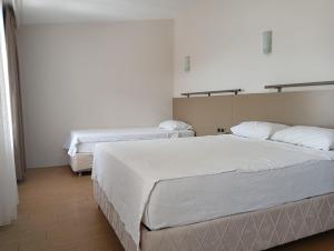 2 camas en una habitación con paredes blancas en Safari Otel, en Antalya