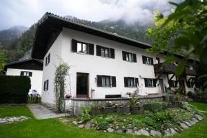 una casa bianca con montagne sullo sfondo di Alpina Haus a Oberammergau