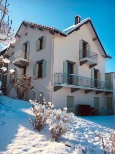 Un grand bâtiment blanc avec de la neige devant lui dans l'établissement La Martichouette Chambres dans Maison vue sur Lac, à Marin