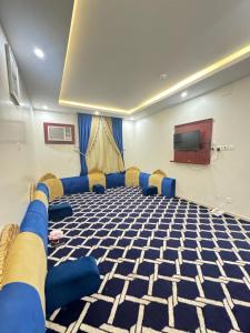 d'une salle de conférence avec des chaises bleues et une télévision à écran plat. dans l'établissement فندق أسس التاج, à Abou Arish