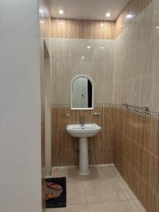 La salle de bains est pourvue d'un lavabo et d'un miroir. dans l'établissement فندق أسس التاج, à Abou Arish