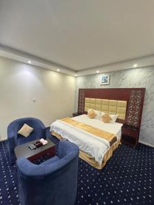 une chambre d'hôtel avec un lit et deux chaises dans l'établissement فندق أسس التاج, à Abou Arish