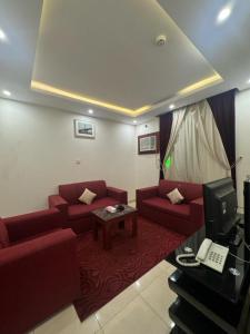 - un salon avec deux canapés rouges et une table dans l'établissement فندق أسس التاج, à Abou Arish