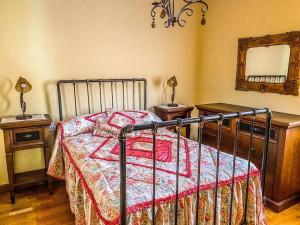 ein Schlafzimmer mit einem Bett mit einer Decke und einem Spiegel in der Unterkunft Casa de Ina in Outes