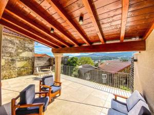 eine Terrasse mit Stühlen und einer hölzernen Pergola in der Unterkunft Casa de Ina in Outes