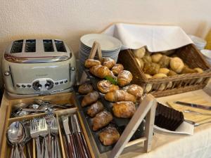 ein Tablett mit Brot und Gebäck auf einer Theke mit einem Toaster in der Unterkunft Hotel Bergschlösschen in Boppard