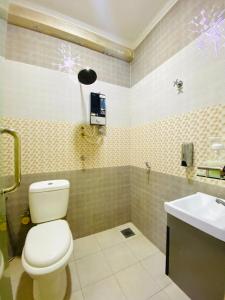 a bathroom with a toilet and a sink at Suza Hostel in Tumpat