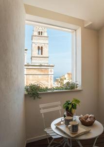 a room with a table and a window with a clock tower at Altavilla in Gaeta