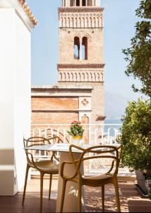 a table and chairs with a clock tower in the background at Altavilla in Gaeta