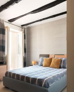 a bedroom with a large bed with blue sheets at Altavilla in Gaeta