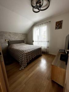 sypialnia z łóżkiem i drewnianą podłogą w obiekcie Logement entier: maison, chez Lucia et Georges w mieście Sucy-en-Brie
