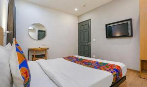 a bedroom with a bed and a flat screen tv at FabHotel Urban Residency in New Delhi