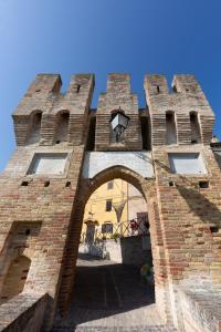 - un grand bâtiment en briques avec une arche devant dans l'établissement Relais Castel d'Emilio - Casa VERDE, à Cassero