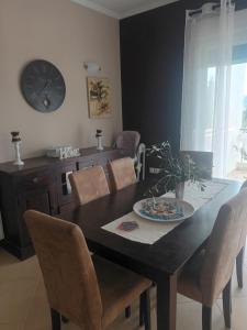 tavolo da pranzo con sedie e orologio sul muro di Thalia suite Corfu Town a Gastouri