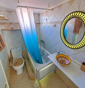 a bathroom with a tub and a toilet and a mirror at HOME SWEET HOME Διαμέρισμα 50τμ σε ήσυχη περιοχή in Orestiada