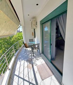 Orestiada的住宿－HOME SWEET HOME Διαμέρισμα 50τμ σε ήσυχη περιοχή，阳台设有玻璃门和桌子。