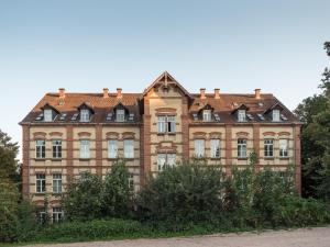 a large brick building with trees in front of it at SCHWARZLINS LoftRaum - Stilvolles Apartment mit Smart TV, NETFLIX, Disney Plus, schnellem WLAN, Parken, Nespresso in Sankt Ingbert