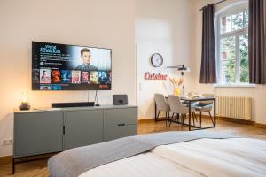 a bedroom with a flat screen tv on the wall at SCHWARZLINS LoftRaum - Stilvolles Apartment mit Smart TV, NETFLIX, Disney Plus, schnellem WLAN, Parken, Nespresso in Sankt Ingbert