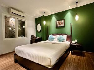 um quarto com uma parede verde e uma cama. em Hanoi Graceful Hotel and Travel em Hanói