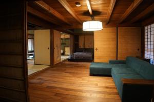 sala de estar con sofá y cama en KOZA River House 湯川邸, en Koza