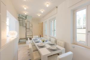 a white dining room with a white table and chairs at Amazing 3 Levels Penthouse Piazza Venezia in Rome