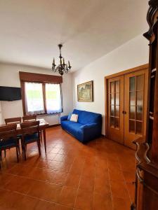 - un salon avec un canapé bleu et une table dans l'établissement Appartamento Jever House, à Rigolato