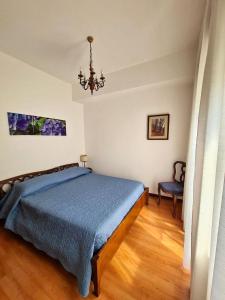 - une chambre avec un lit bleu et un lustre dans l'établissement Appartamento Jever House, à Rigolato