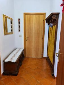 une chambre avec une porte et un banc à côté d'une porte dans l'établissement Appartamento Jever House, à Rigolato