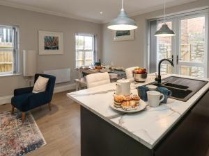 a kitchen and living room with a table with food on it at 3 Compass Point in Weymouth