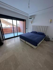 1 dormitorio con 1 cama en una habitación con balcón en Grand duplex idéal pour famille, en Marrakech