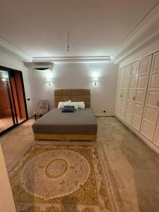 1 dormitorio grande con 1 cama y 1 alfombra en Grand duplex idéal pour famille, en Marrakech