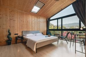 1 dormitorio con cama y ventana grande en Kabins - Homestay Near Pawna Lake, Lonavala en Lonavala
