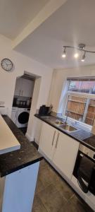eine kleine Küche mit einem Waschbecken und einem Fenster in der Unterkunft Silver Serenity in Stoke on Trent